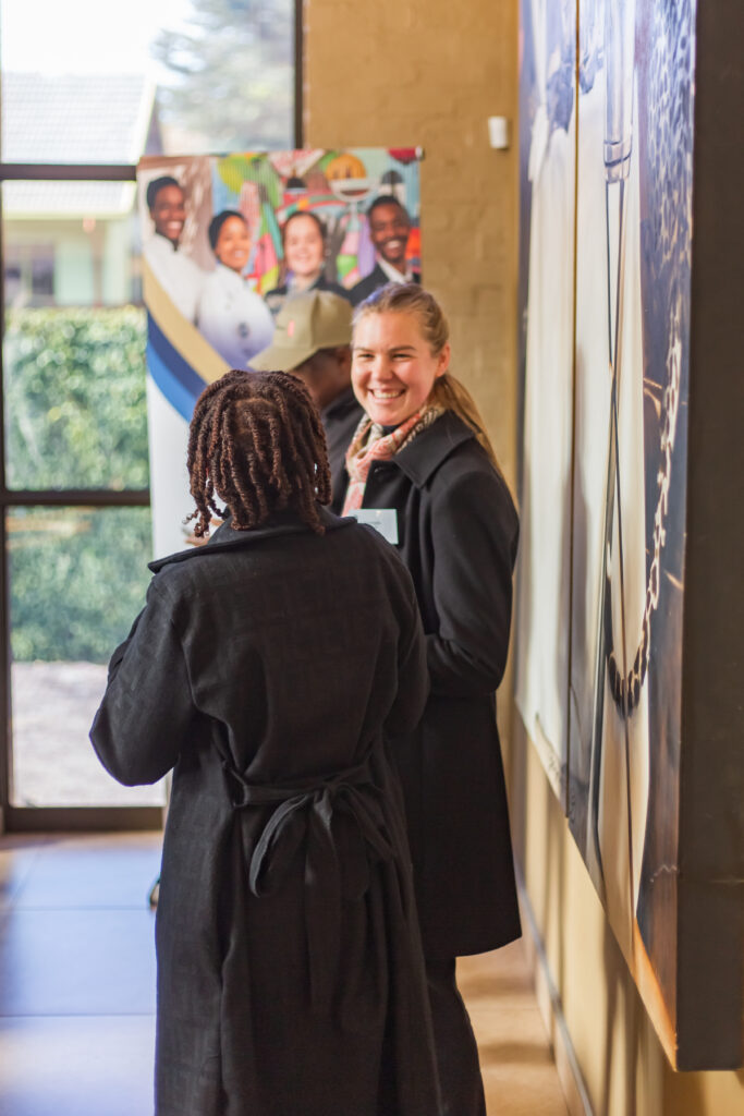 Guests with name tags smiling and talking near a branding banner during the corporate hospitality networking event.